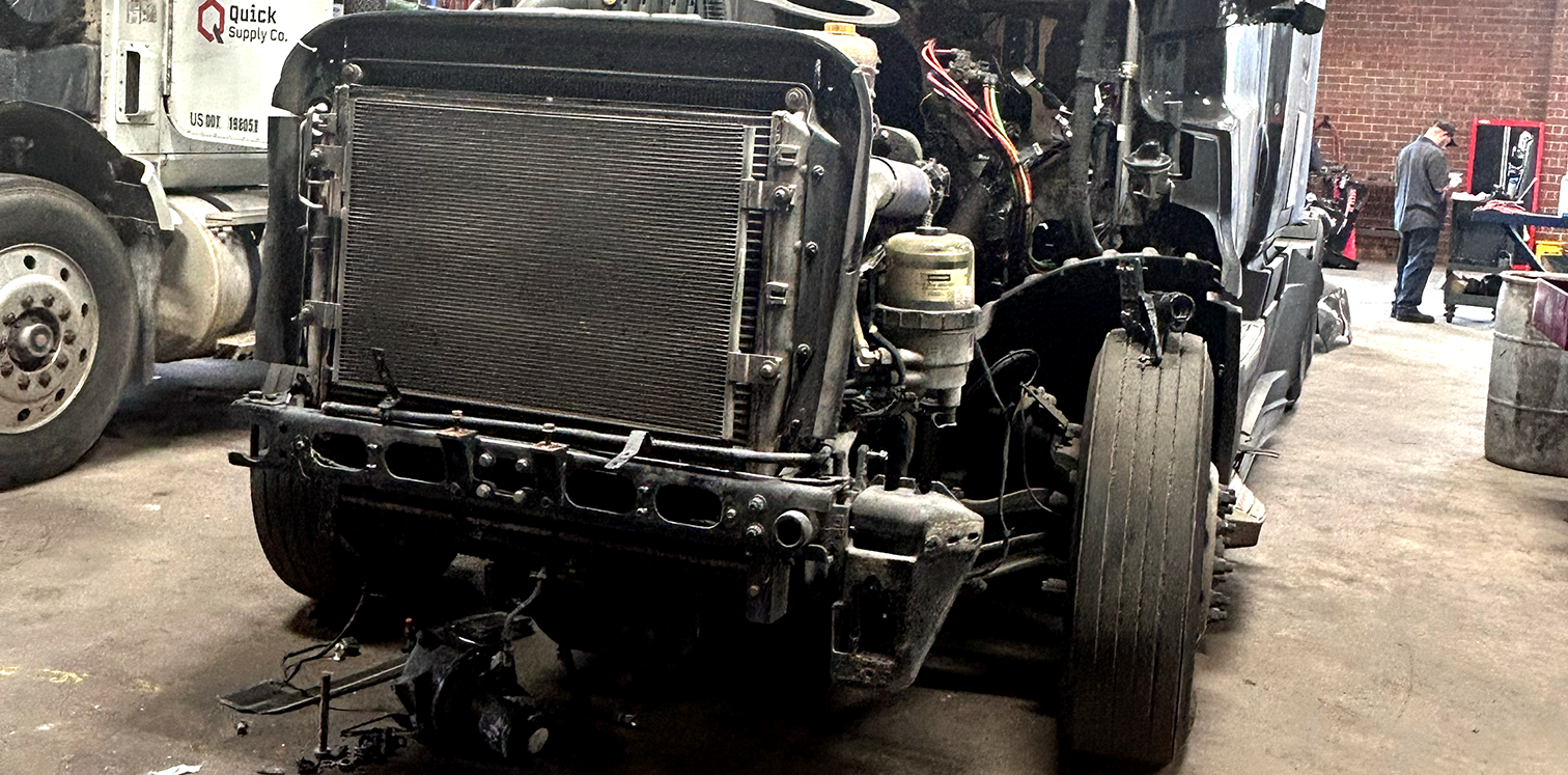 Technician servicing the coolant system of a heavy-duty truck